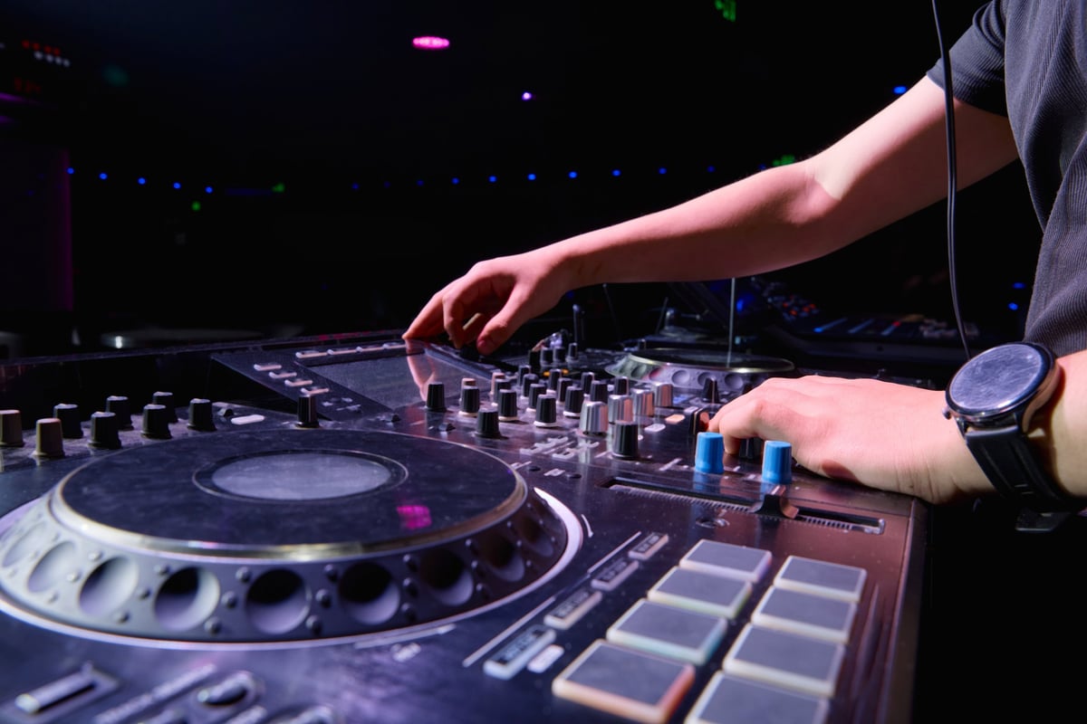 DJ behind the decks in a dark club
